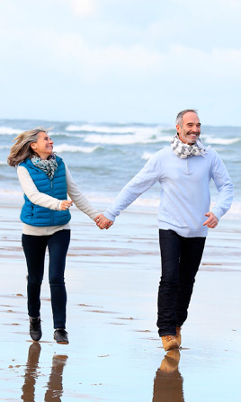 Una pareja de la mano caminando en la playa