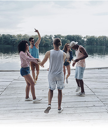 Personas bailando frente a un lago