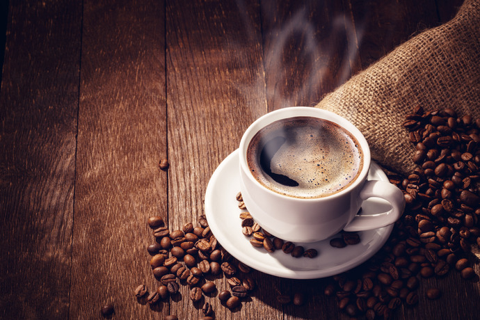 Taza de café con granos sobre madera