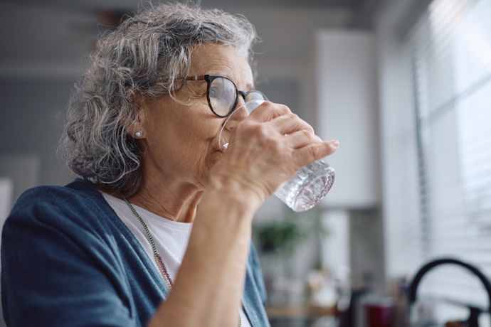 Mujer toma agua para controlar hipo