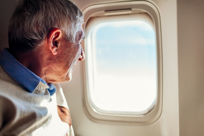 Hombre viendo hacia afuera de una ventana de avión