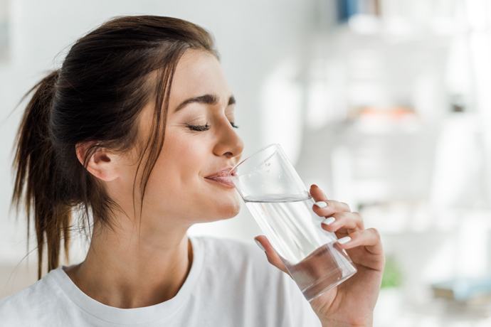 Mujer disfrutando de un vaso de Agua