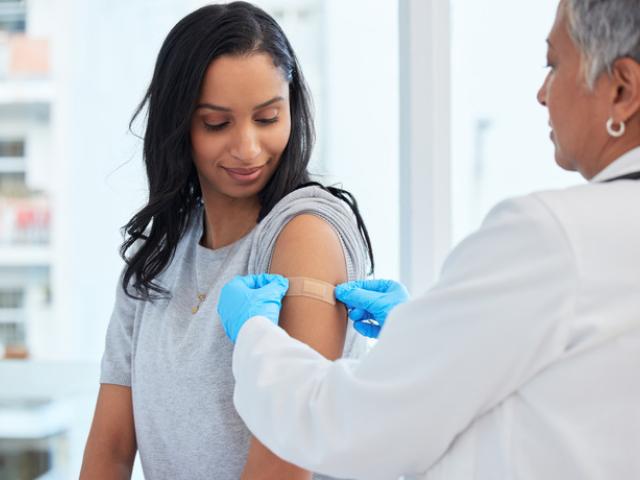 Sanitario a punto de poner una vacuna en el brazo de una chica